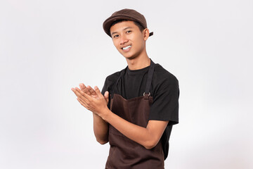 handsome barista asian man wearing brown apron and black t-shirt isolated over white background...