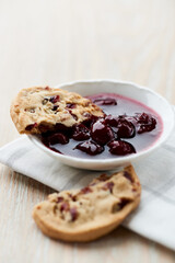 Cranberry cookies with jam on bright wooden background. Close up. 