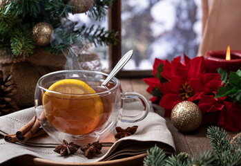 Steaming hot tea with lemmon slice with holiday decorations