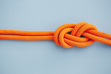 Eight knot on a rope on a blue background. Copy space