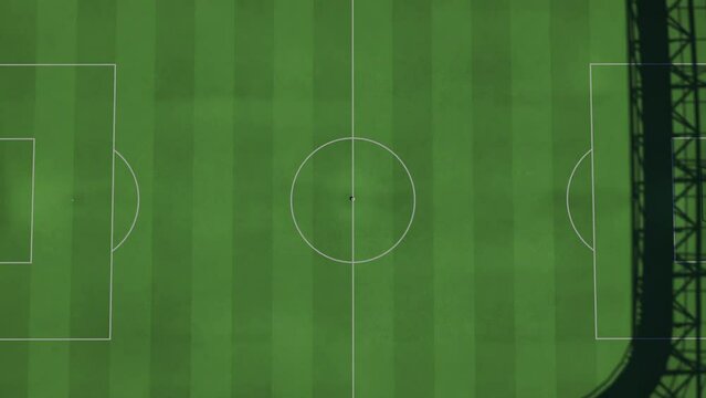 Camera zooms out from the middle of a full football or soccer stadium, soccer ball in the middle, top view. Kickoff moment.