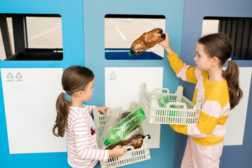 Kids sorting plastic by polymer type and  taking out plastic trash in recycling centre. Sustainble lifestyle concept. National recycling week.