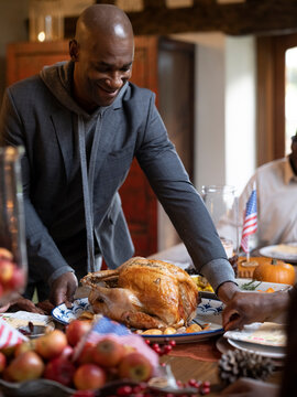 Man putting turkey on Thanksgiving table