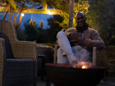 Man sitting by fire pit on patio