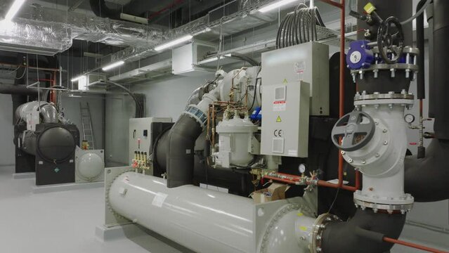 Central heating and cooling system installed with motor machine and pipelines in an industrial factory building