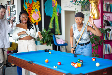 Friends playing pool together at home