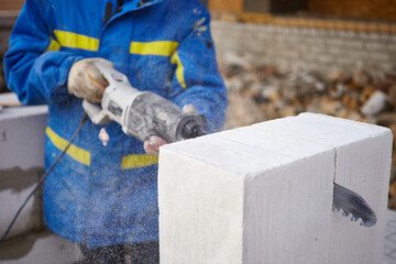 The bricklayer works with white blocks