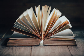 Open old book on dark background, vintage  book with open pages on wooden desk, selective focus