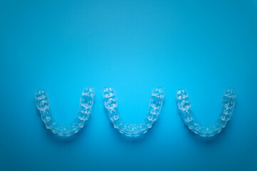 row of aligners, side view, on a blue background