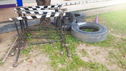 Piles of old wooden mix with metal hurdles on the ground with black old car tires