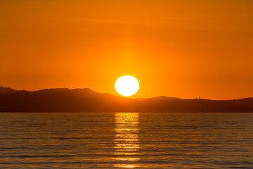 Scenic view of sun globe reflected to Mediterranean sea at golden sunset in south of France