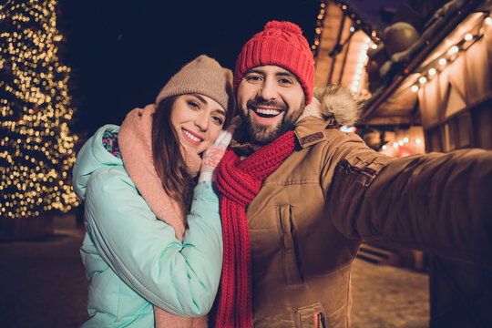 Photo of positive pretty girlfriend boyfriend tacking selfie cuddling walking outdoors urban city market