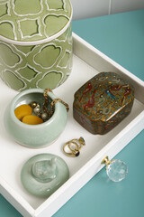 Jewelry and jewelry boxes on a plain white leather tray