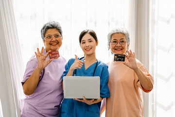 Asian elderly woman smiled happily held a credit card in her hand with doctor holding a laptop...