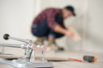 man is cutting a tile