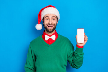 Portrait of funny positive handsome guy hold showing empty space telephone screen isolated on blue color background