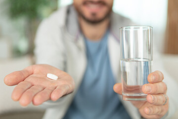 closeup shot of pills and glass of water