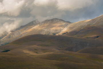 Fototapeta premium View of dark cloud over high mountains near Castelluccio di Norcia in Umbria Italy