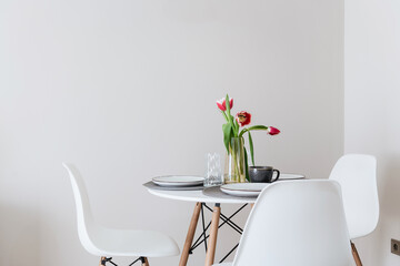 a table with chairs on a white wall background in a new apartment