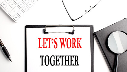 LET'S WORK TOGETHER text written on paper clipboard with office tools