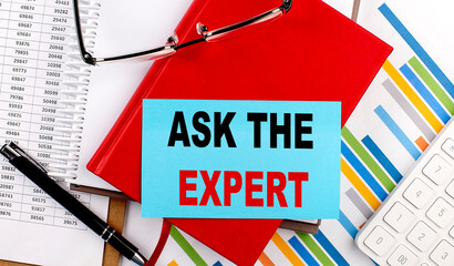 ASK THE EXPERT text on sticky on red notebook on chart background