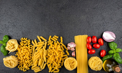 Fototapeta na wymiar Different raw pasta with copy space on black background. Top view of Italian cuisine ingredient.