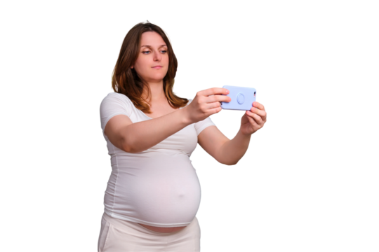 Shooting a video on a mobile phone of a pregnant woman, a studio shot on a white background