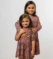 Portrait of two fashionable sisters wearing similar outfits 