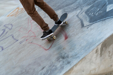 Selective cropping of a young skater practicing at a skate park.