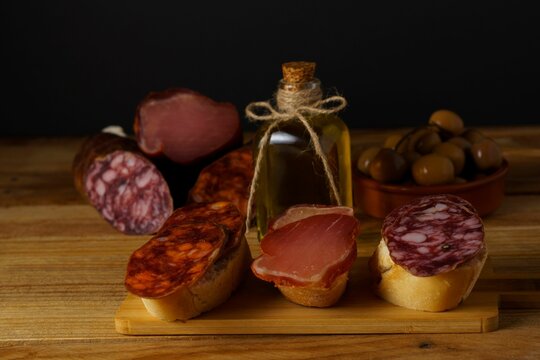 Tapas With A Variety Of Iberian Sausages On A Wooden Board