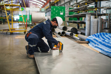 Male worker inspecting surface on plate stainless