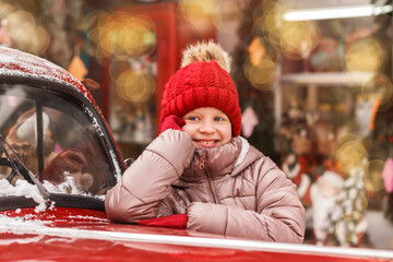 Christmas Child Girl Teen Smiling Enjoying Christmas Shop Windows near Red Car. New Year Shopping