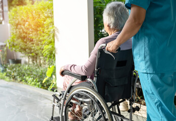Caregiver help and care Asian senior or elderly old lady woman patient sitting in wheelchair on...