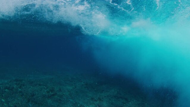 Underwater view of the surfer riding the ocean wave