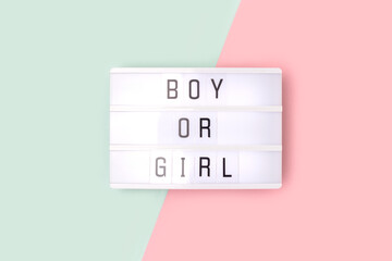 Boy or girl. Lightbox with letters on a pink and blue background. Gender reveal concept.