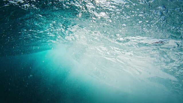Surfing etiquette. Woman surfer drops in another girl on the wave and keeps riding