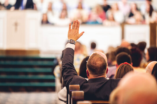Man at church with His Hand Raised