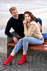 Beautiful young couple sitting on a bench in the city during a romantic date