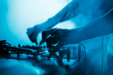 Disc jockey mixing music set on stage in nightclub. Club DJ playing musical tracks with sound mixer
