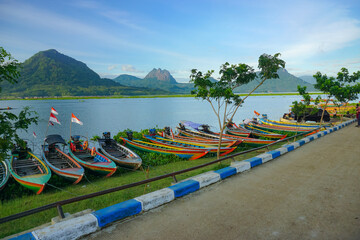 Fishing boats anchored on the banks of the Jatiluhur reservoir. Beautiful view with mountains in the background.