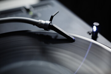 Turntables needle on vinyl record. Professional dj turn table player device in closeup
