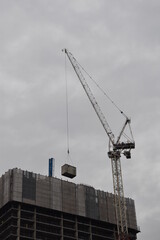 Fototapeta premium Construction work in the city with large cranes and a grey sky background. Taken in Manchester England. 