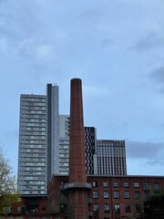 Fototapeta premium Old mill with modern buildings behind it. Taken in Manchester City centre. 