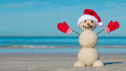 Sandy Christmas snowman on the beach. Snowman from sand. Merry Christmas celebration party....