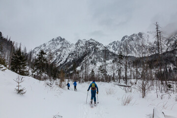 Guide and two backcountry skitourers in snowy High Tatras, the mountain range and national park in Slovakia