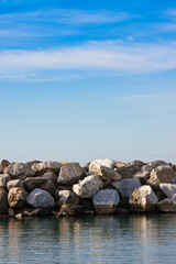 Obraz premium Dam with stone blocks for protection from sea storms - image with copy space
