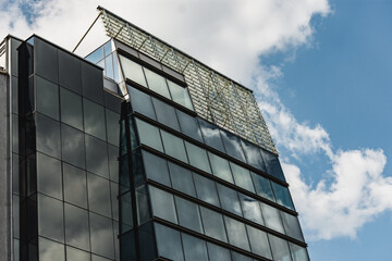 Minimalist office building design. Corporate structure with many windows in which clouds are reflected