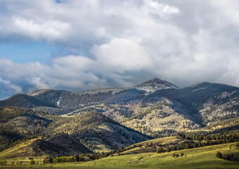 Sangre de Cristo Mountains east of Taos New Mexico with two houses in distance and snowy peak in background
