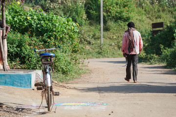 Rural Indian man going to his agriculture farm field holding hand scythe at morning in village, indian farmer going to work, farmer - Powered by Adobe