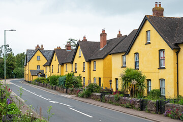 Fototapeta na wymiar Uniformly painted houses lining a village roadside in East Devon, UK